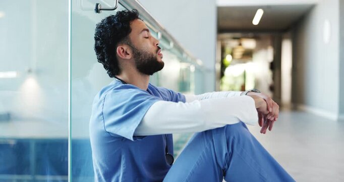 Man, nurse and headache in burnout, stress or mistake on floor in hospital. Mental health, sad physician and medical person with healthcare anxiety for grief, loss or failed surgery at clinic