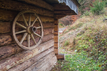 Obraz premium Old Wooden Wagon Wheel as Wall Decoration in Carpathian House