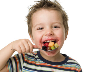 A joyful child delighting in a colorful mix of fresh fruit, showcasing pure happiness.