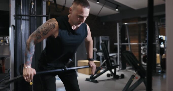 A man doing pullover exercise on training apparatus pumping his muscles in the gym