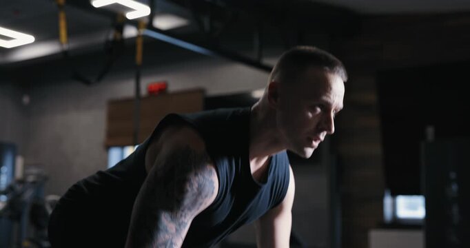 A man doing bent-over barbell row exercise pumping his muscles in the gym