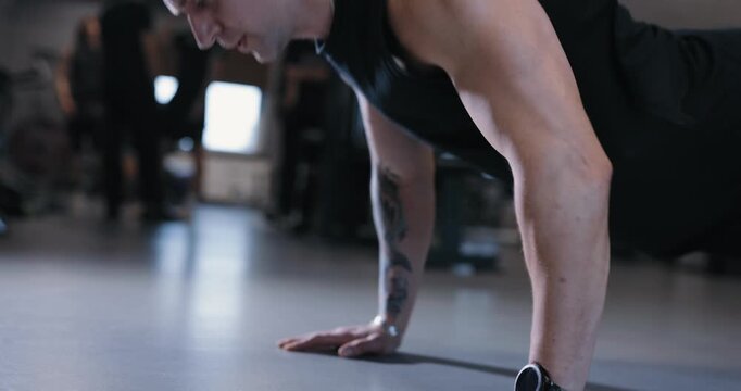 A man doing push-ups exercise pumping his body in the gym