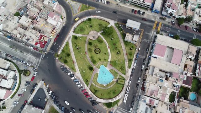 aerial view Callao roundabout fountain park showcasing oval green garden, turquoise basin