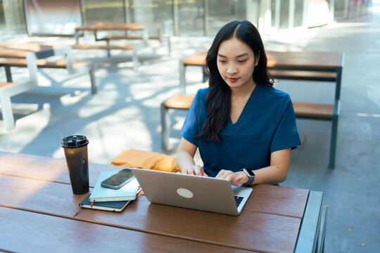 Female healthcare professional working on laptop outdoors