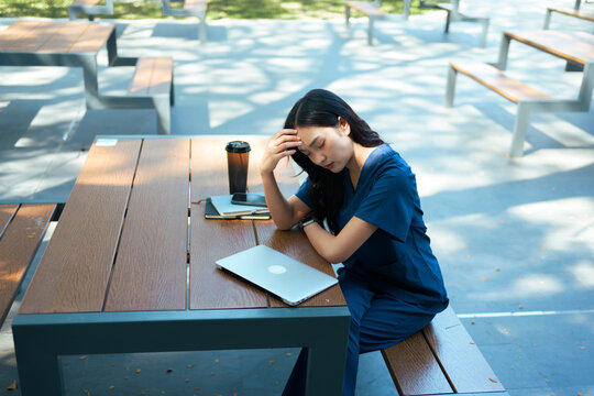 Exhausted female medical professional experiencing stress and burnout outdoors