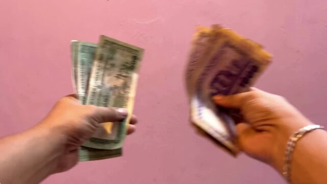 Two hands holding and showing 1000 Bangladeshi Taka banknotes. Concept of currency exchange and payment.
