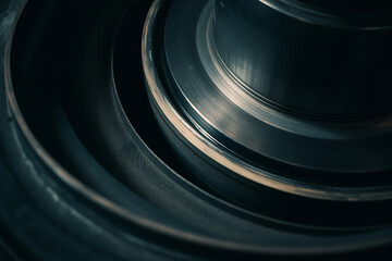 Abstract close-up of layered metallic rings with dark, cool tones and subtle reflections, evoking depth and precision.