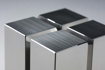 Four polished metallic blocks arranged in a cube formation, representing abstract design, structure, and modern aesthetics.