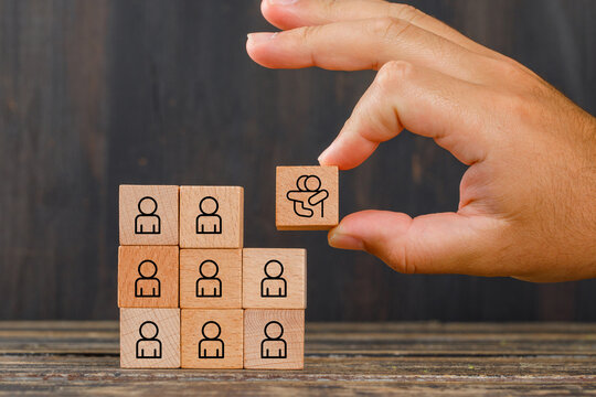 Empathy in the workplace concept. Wooden block with an icon of two people hugging, symbolizing empathy among team member icon. Emotional intelligence, collaboration, trust within a professional team.