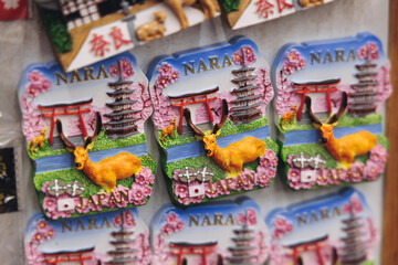 Obraz premium Japanese tourist souvenirs, presents and travel gifts from Nara, Japan, spotted deer figures, key ring keychain, fridge magnets, sika deer plush toys figurines, shopping in a local vendor gift shop