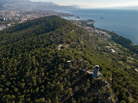 Epic forest park tower panorama. 
Cinematic aerial drone view 
of Marjan hill observatory 
and Split cityscape in 
Croatia. 4K nature landscape.
