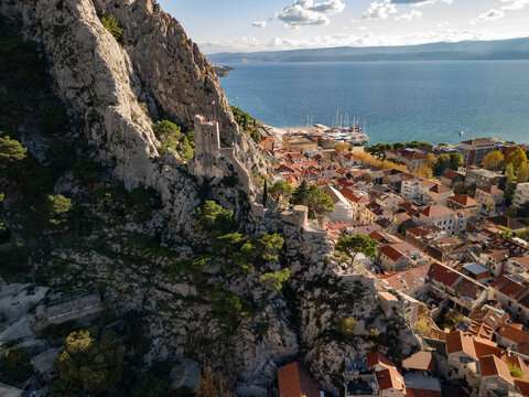 Horizontal aerial view of the historic Mirabella Fortress (Peovica) on a rock. Old town with red roofs and Adriatic sea in Omis, Croatia.