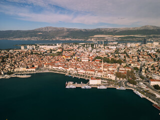 Fototapeta premium Aerial medium shot of Saint Domnius bell tower and Diocletian's Palace in Split, historic stone architecture and red roofs under sunny sky, Croatia, 4K