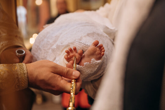 A close-up photo of a child's leg in the church during baptism. Children's christenings. Traditions for children