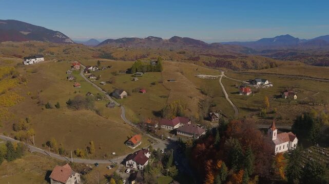 Sweeping Aerial Pan Revealing Sirnea Valley and Village Pestera under Snow Capped Piatra Craiului
