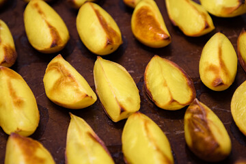 Obraz premium Baked yellow fruits arranged on a dark surface after cooking at a kitchen