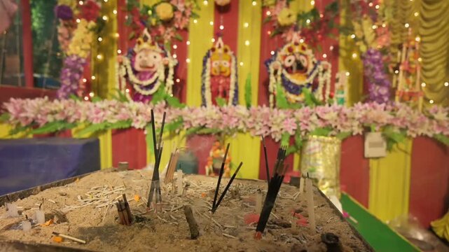 Candle sticks burning in front of idols of Lord Jagannath, Balaram and Suvodra. Indian Rath jatra festival. Howrah, West Bengal, India.