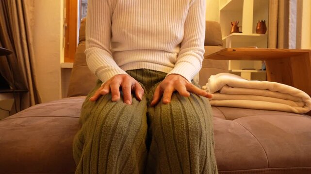 Woman exhibiting anxiety and restlessness on a couch