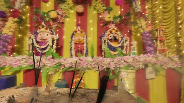Candle sticks burning in front of idols of Lord Jagannath, Balaram and Suvodra. Indian Rath jatra festival. Howrah, West Bengal, India.