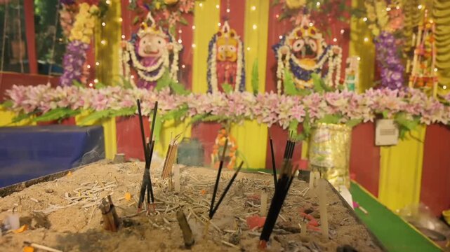 Candle sticks burning in front of idols of Lord Jagannath, Balaram and Suvodra. Indian Rath jatra festival. Howrah, West Bengal, India.