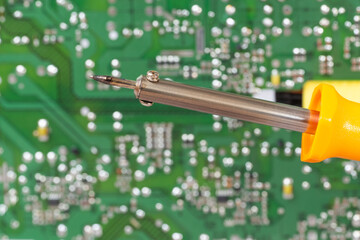 electrical board with a soldering iron and screwdrivers