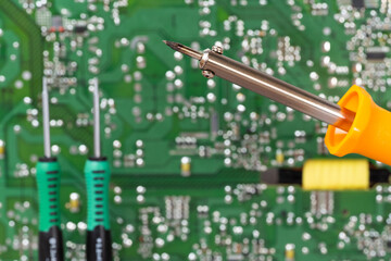 electrical board with a soldering iron and screwdrivers