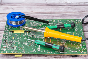 electrical board with a soldering iron and screwdrivers
