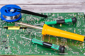 electrical board with a soldering iron and screwdrivers