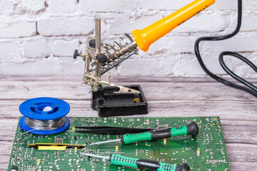 electrical board with a soldering iron and screwdrivers