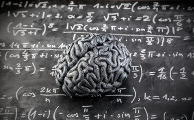 Human brain model with mathematical equations on scholl chalkboard. Science, education and learning concept.
