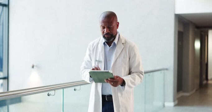 Healthcare, tablet and walking with doctor black man in hospital for planning or research. App, medical and reading with mature African person in clinic hallway for insurance or review of information