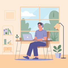 Man with headphones working on laptop at home office with window view