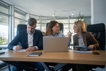 Fototapeta premium Laptop, collaboration and business people in the office while working on a company project. Technology, teamwork and team doing corporate research in discussion together with technology in workplace