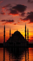 Fototapeta premium A dramatic silhouette of a magnificent mosque, featuring a large central dome and several tall, slender minarets, stands against a breathtaking sunset.