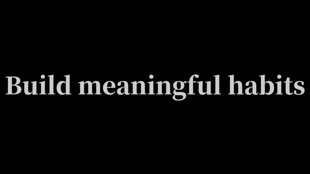 The phrase 'Build meaningful habits' appears in clean white typography centered on a dark background, encouraging the formation of positive daily routines.