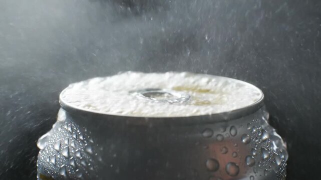 Opening a cold, wet soda can with a splash and fizz, close-up