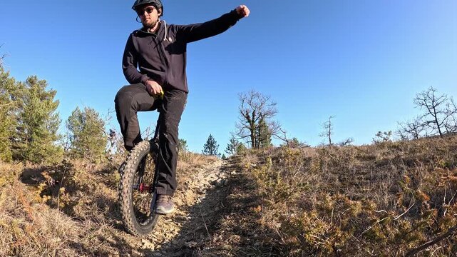 Mountain unicycle or MUNI rider descends a technical trail
