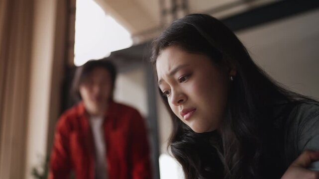 Depressed Asian woman listening to boyfriend's accusations, toxic relationship