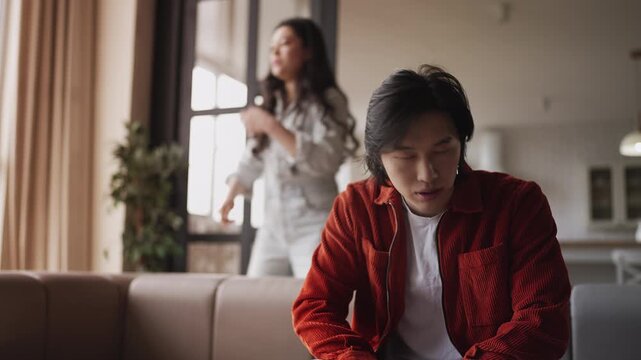 Displeased Asian woman accusing her boyfriend during relationship crisis