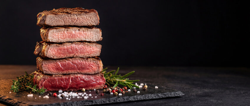 Five steaks stack showcases doneness degrees chart, Blue, Rare, Medium Rare, Medium, Medium well. Copy space, dark background