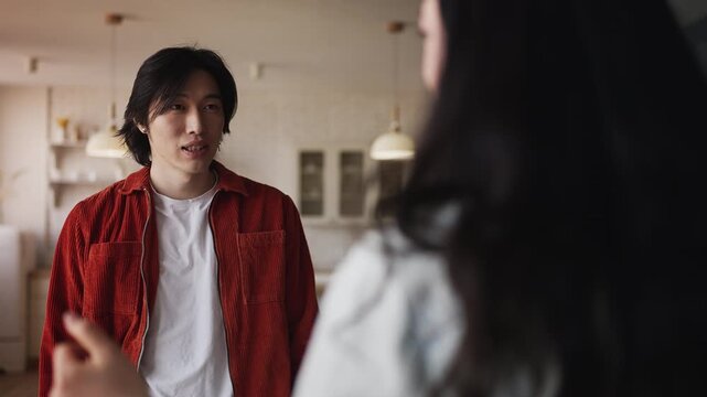 Young Korean couple fighting at home, stressed man shouting at girlfriend