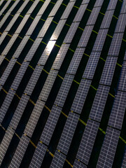 Solar panels arranged in rows during sunny day at renewable energy site in land area for clean electricity generation