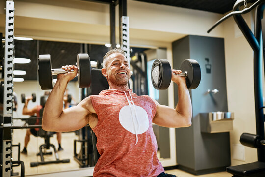 Man Lifting Dumbbells At The Gym Showing Strength And Determination