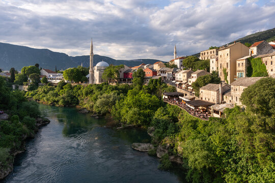 Aerial view of the Neretva River winding past historic buildings and mosques, with light playing on stone and minarets, Mostar, Federation of Bosnia and Herzegovina, Bosnia and Herzegovina.