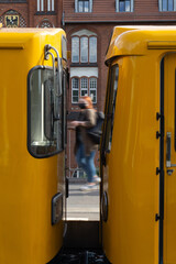 Iconic Yellow Berlin U-Bahn Subway Cars at Historic Red Brick Station with Passenger in Motion Blur Urban Public Transit Scene in Germany