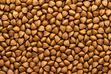 Buckwheat groats macro texture filling the frame. Crisp high-detail food grain background ideal for nutrition concepts, healthy eating visuals, packaging and clean design applications.