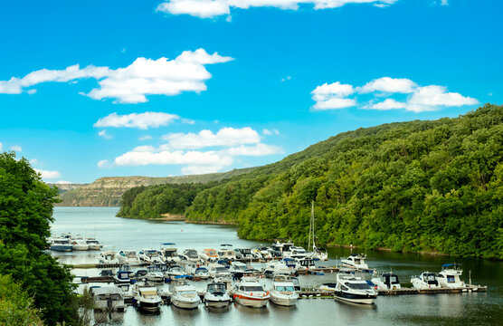 Yacht club for light boats in a tributary of the river against a blue sky with clouds
