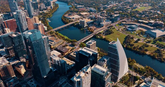 The Colorado River flowing through the beautiful cityscape of Austin, Texas, USA. Flying over the glass high-rises in modern downtown.