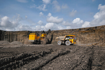 Process of removing overburden in quarry. Vast open pit coal mine with heavy machinery operations...