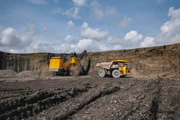 Fotobehang Natuur Park Process of removing overburden in quarry. Vast open pit coal mine with heavy machinery operations under blue sky  © Parilov